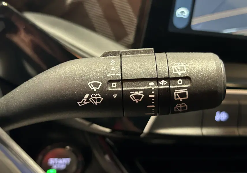 Gros plan sur la manette des essuie-glaces à l'intérieur du MG3 Cosmic Silver 2026, avec écran tactile en arrière-plan.