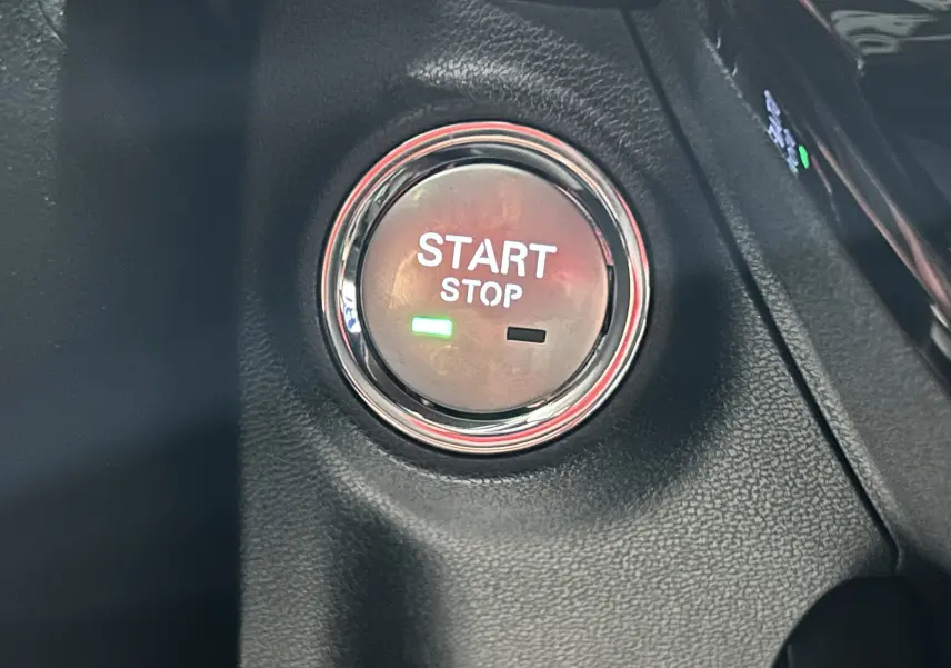 Bouton Start Stop éclairé en vert sur tableau de bord noir du MG MOTOR MG3 Hybrid+ 195 Luxury Cosmic Silver 2026.