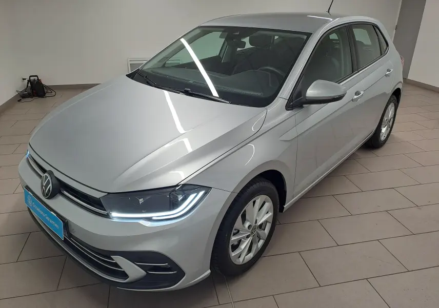 Volkswagen Polo 1.0 TSI Style en reflet d'argent, vue 3/4 avant droit dans un showroom intérieur.