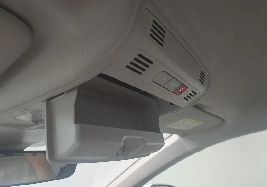 Vue intérieure du plafond avant côté conducteur d'une Volkswagen Polo argent avec compartiment lunettes ouvert et commandes intégrées.