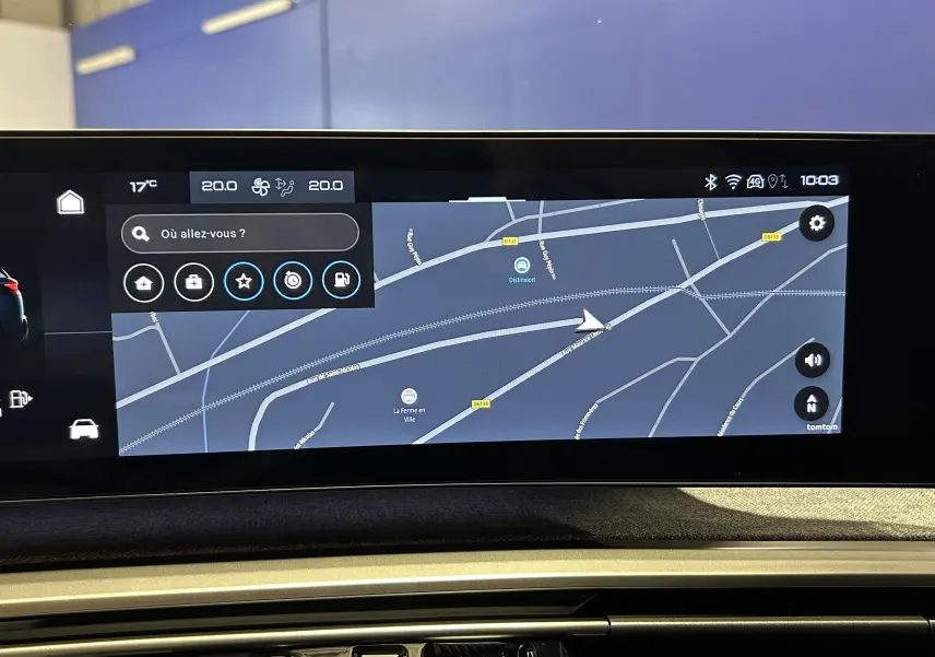 Écran tactile intérieur du Peugeot 5008 Hybrid 2025 montrant la navigation GPS avec interface moderne et fond gris.