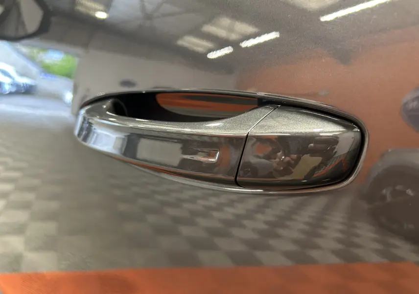 Poignée de porte gris titane en gros plan sur le côté droit du Peugeot 5008 Hybrid 145ch e-DCS6 GT 2025.