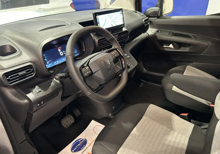 Intérieur du Citroën Berlingo Multispace 2026 vu côté conducteur, volant cuir, écran tactile central et sièges bicolores.