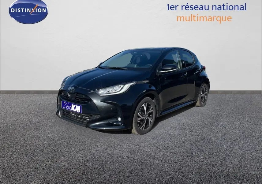 Toyota Yaris Hybrid noir métal vue 3/4 avant droit avec jantes bi-ton et feux LED allumés.