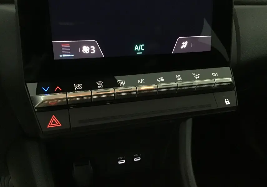 Vue rapprochée de la console centrale du Renault Captur 2025 montrant les commandes tactiles de climatisation et les ports USB.
