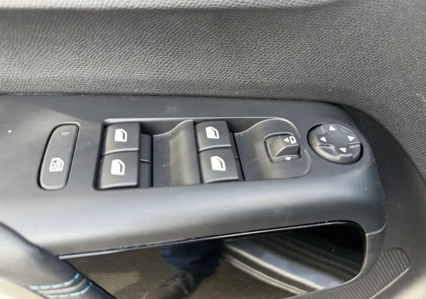Gros plan sur les commandes des vitres et rétroviseurs côté gauche d'une Citroën C5 Aircross gris Artense 2024.