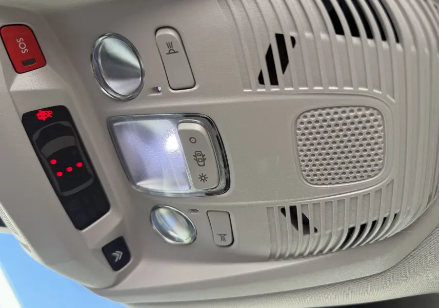 Plafonnier intérieur gris clair du Citroën C5 Aircross 2024 avec commandes d'éclairage et bouton SOS rouge.
