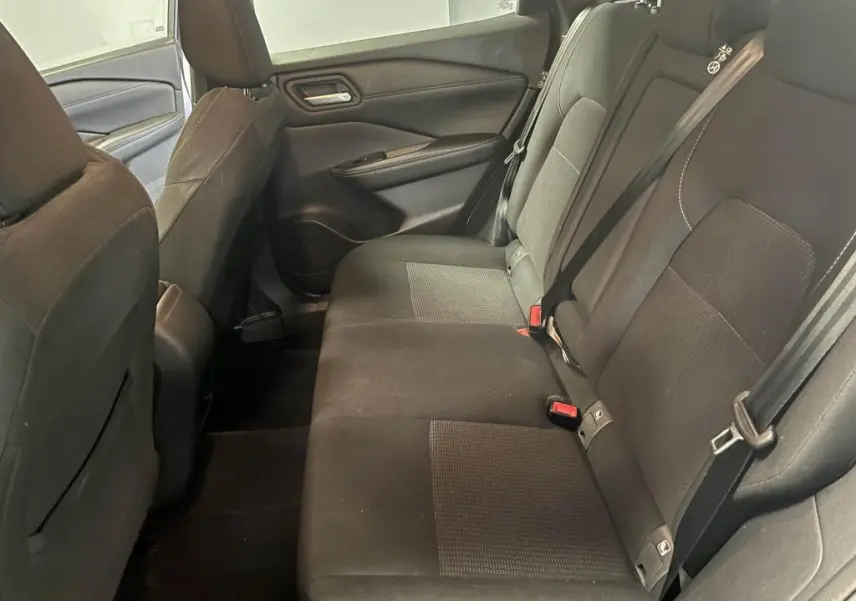 Vue côté droit de la banquette arrière noire en tissu du Nissan Qashqai 2023, avec ceintures de sécurité et appuie-têtes.