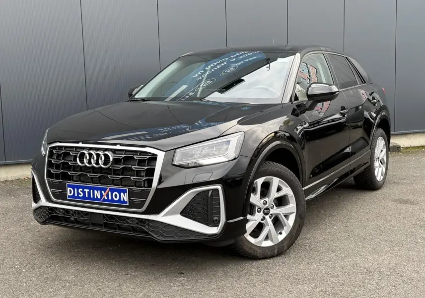 Audi Q2 noir métallisé en vue 3/4 avant droit, mettant en valeur sa calandre distinctive et ses jantes S line.