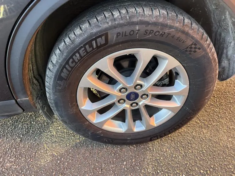 Gros plan sur la roue avant droite du Ford Kuga gris métallisé, jante alliage 17 pouces avec pneu Michelin Pilot Sport 4 SUV.