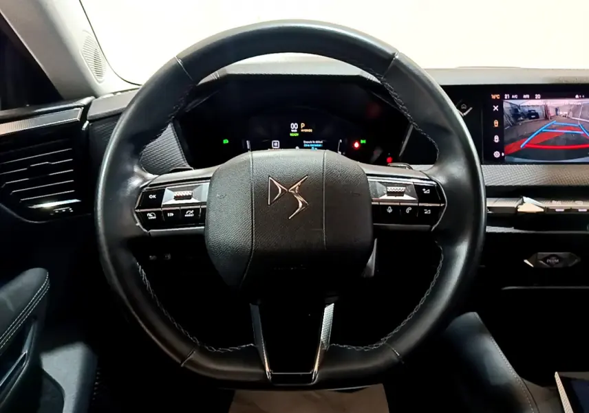 Vue frontale du volant cuir DS de la DS4 E-TENSE 225 TROCADERO 2023 avec tableau de bord numérique et écran tactile de recul.