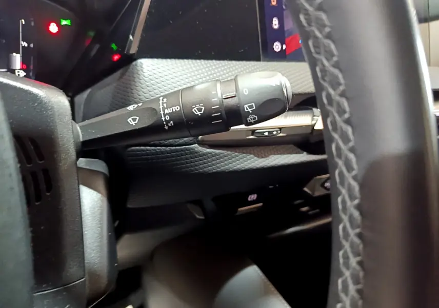 Gros plan sur la commande d’essuie-glace à gauche du volant cuir dans l’habitacle du DS4 E-TENSE gris foncé 2023.