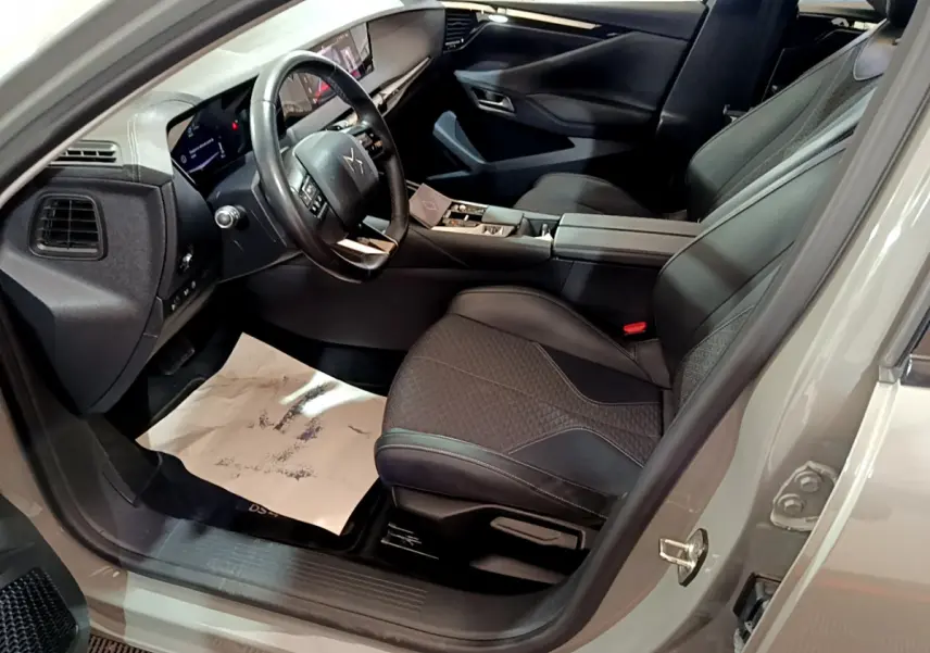 Intérieur côté conducteur du DS4 E-TENSE 225 TROCADERO gris foncé, volant cuir et sièges noirs élégants en vue rapprochée.