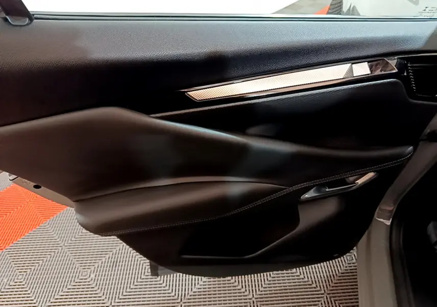 Gros plan sur la porte côté droit du DS4 E-TENSE 225 TROCADERO 2023 avec garniture noire et insert décoratif argenté.