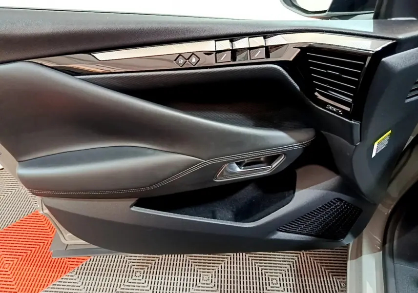 Vue rapprochée de la porte avant droite du DS4 E-TENSE 225 TROCADERO gris foncé, avec commandes de vitres et poignée intégrée.