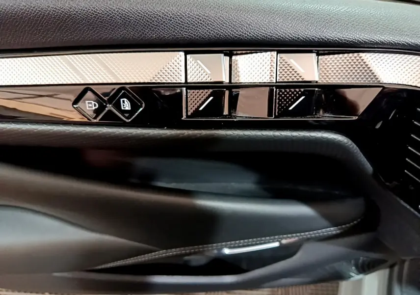 Détail de la porte côté conducteur du DS4 E-TENSE 225 TROCADERO 2023 gris foncé avec commandes de vitres et verrouillage.