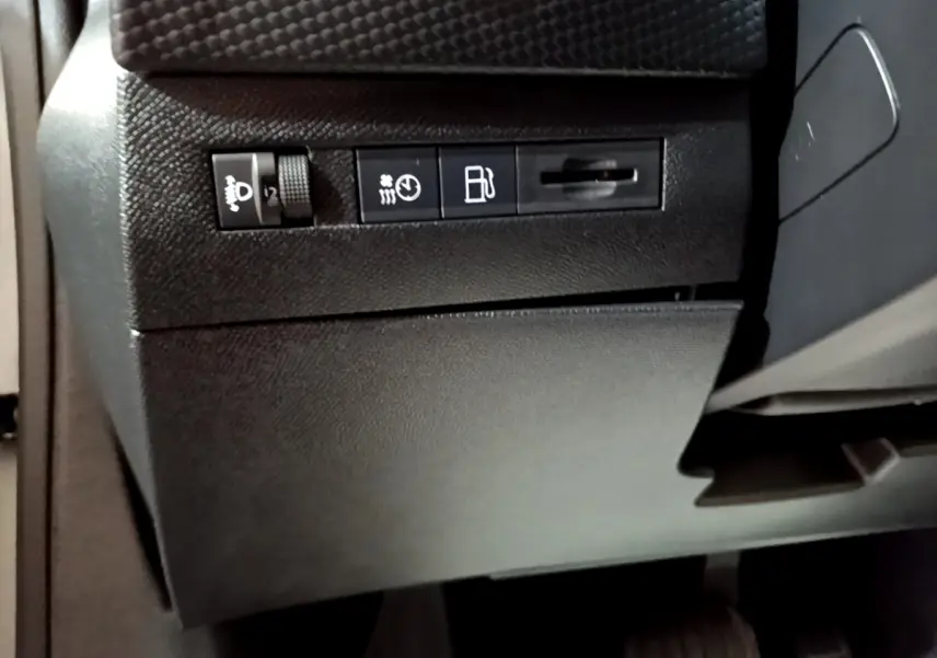 Vue rapprochée des commandes de réglage des phares et du tableau de bord côté gauche intérieur du DS4 E-TENSE gris foncé 2023.