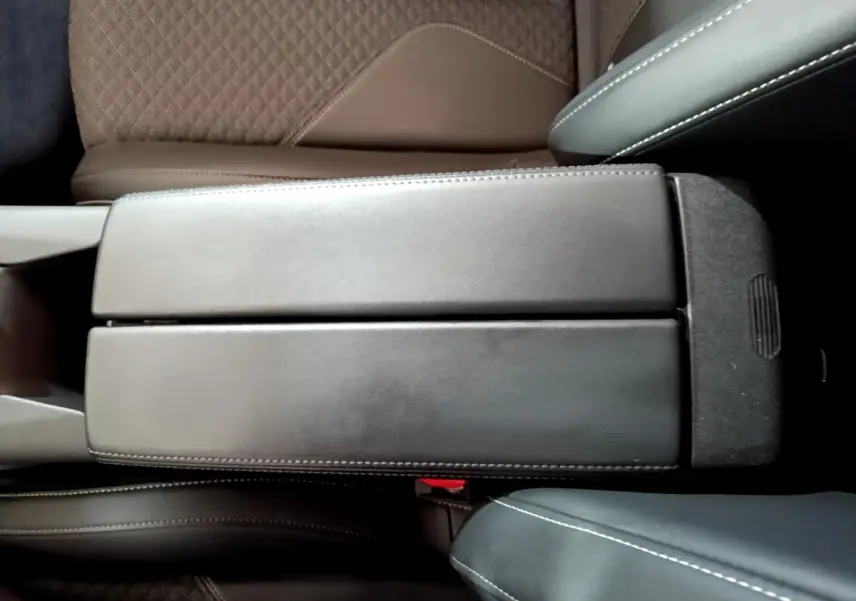 Vue plongeante sur l'accoudoir central noir et les sièges marron et noir du DS4 E-TENSE 225 TROCADERO 2023.