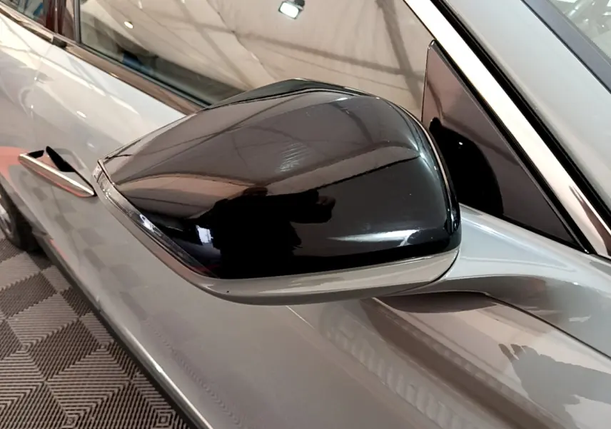 Gros plan sur le rétroviseur noir côté gauche du DS4 E-TENSE 225 TROCADERO gris foncé 2023.