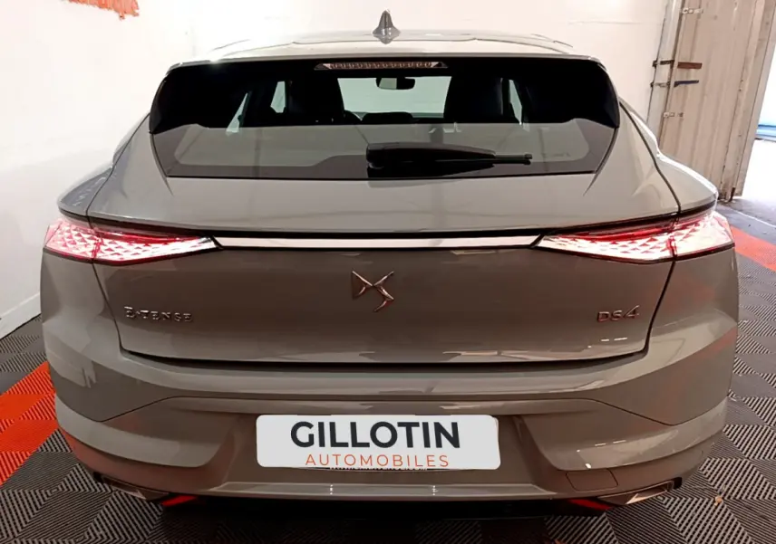 Vue arrière d'une DS4 E-TENSE 225 TROCADERO hybride rechargeable gris foncé avec feux LED allumés en intérieur