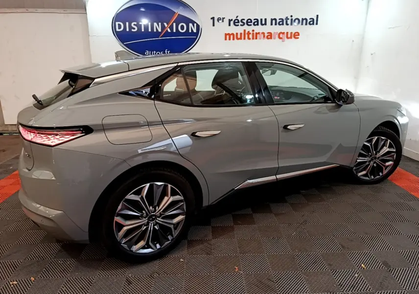 Vue latérale droite d'une DS4 E-TENSE 225 TROCADERO gris foncé avec jantes alliage et feux arrière LED allumés.
