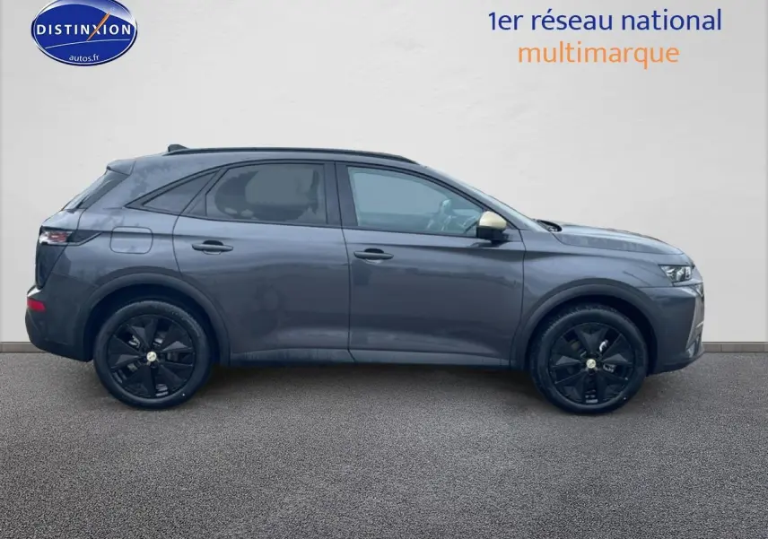 Vue latérale droite d'un DS7 gris titane avec jantes noires et vitres arrière surteintées sur fond neutre.