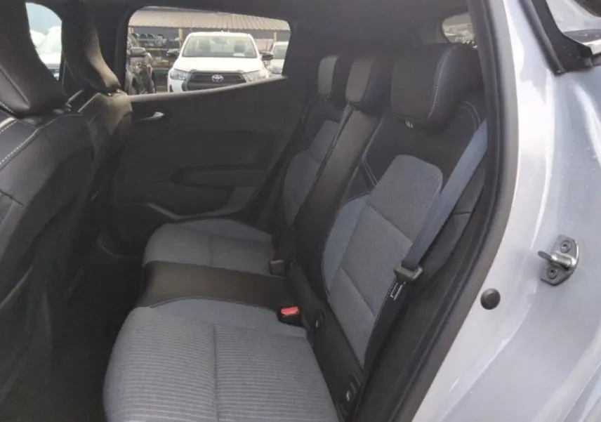 Vue intérieure côté droit sur la banquette arrière gris clair et noir de la Renault Clio 2025 avec ceinture de sécurité visible.