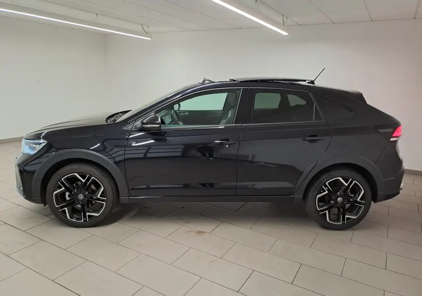 Profil droit d'un Volkswagen Taigo noir intense nacré 2025 avec jantes alliage noires et toit ouvrant visible en intérieur.