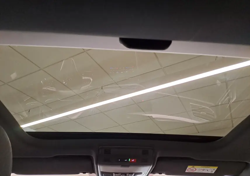 Vue intérieure du toit ouvrant en verre du Volkswagen Taigo 2025, avec commandes intégrées et ciel de pavillon noir.