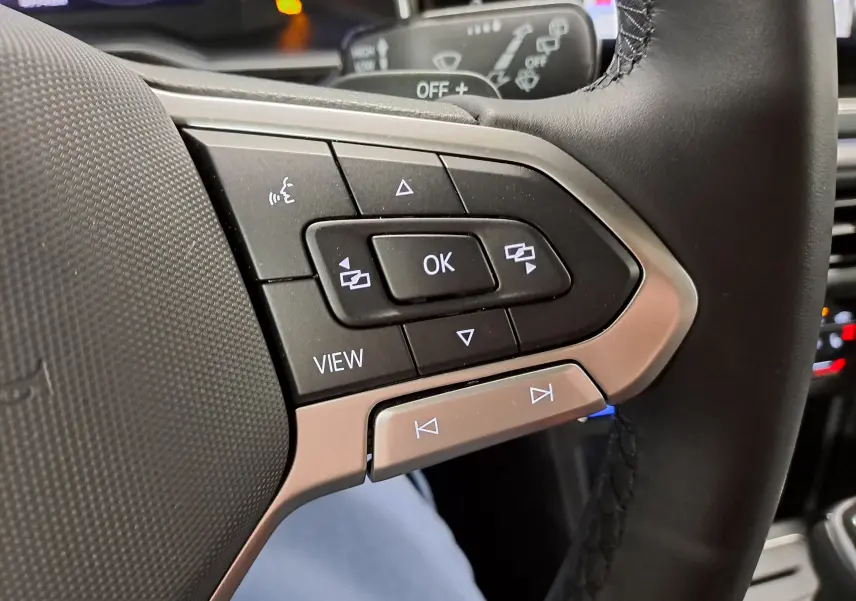 Gros plan sur les commandes multifonctions à droite du volant cuir du Volkswagen Taigo 1.5 TSI R-Line, finition noire.
