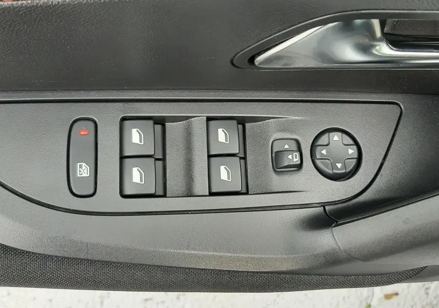 Panneau de commandes des vitres et rétroviseurs côté conducteur d'une Peugeot 2008 blanche, avec insert décoratif orange.