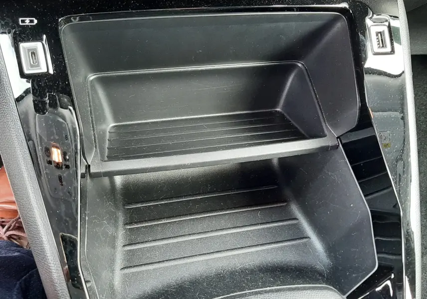 Gros plan sur le rangement central noir brillant avec ports USB du Peugeot 2008 blanc, version essence 2021.