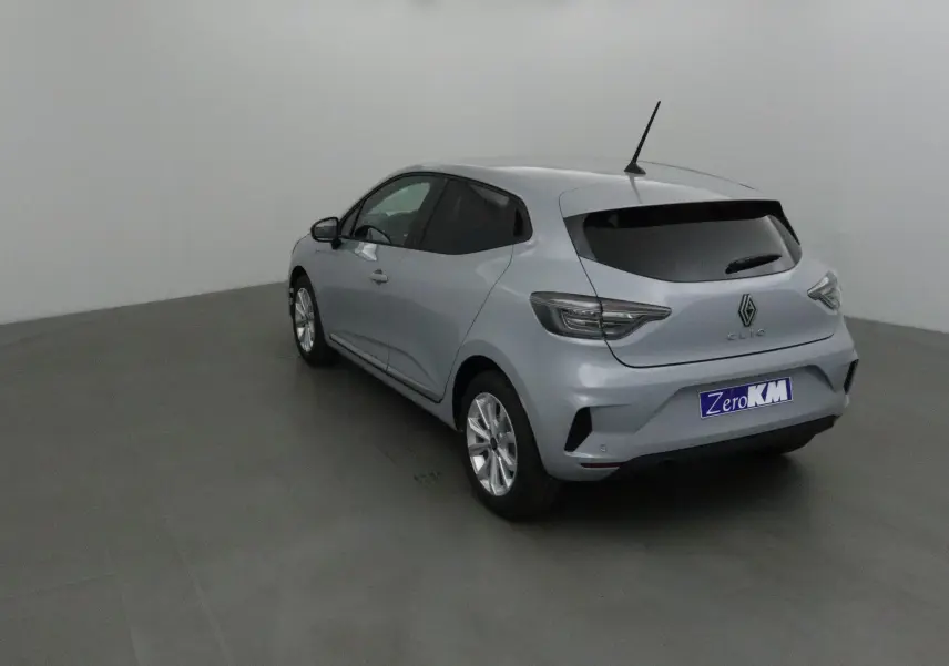 Vue 3/4 arrière gauche d'une Renault Clio V gris Rafale avec vitres teintées et protections latérales chromées.