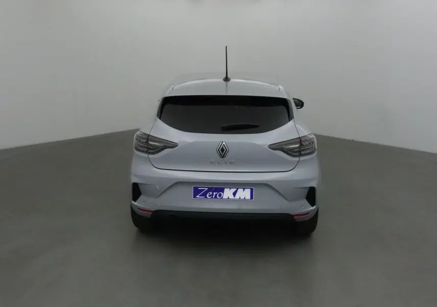 Vue arrière d'une Renault Clio V gris Rafale 2025 avec feux LED et protections latérales chromées visibles.