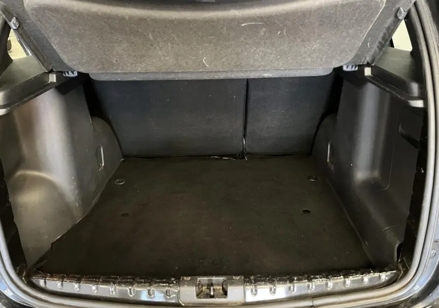 Coffre ouvert du Dacia Duster noir 2016, vue intérieure arrière montrant l'espace de chargement vide.