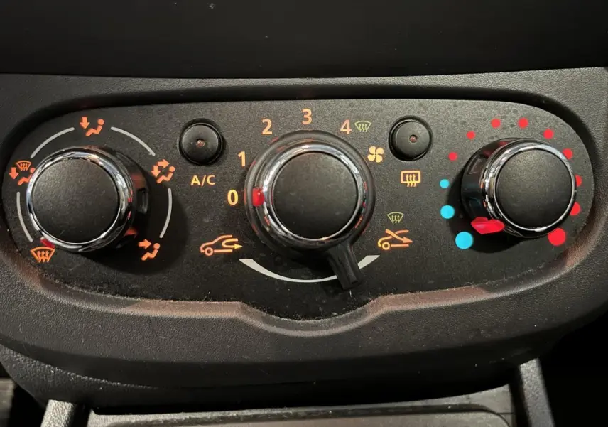 Commandes de climatisation noires avec réglages de température, ventilation et distribution d'air sur Dacia Duster noir 2016.