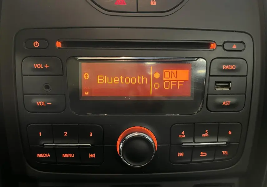 Console centrale du Dacia Duster noir 2016 avec écran radio affichant Bluetooth activé en lumière orange