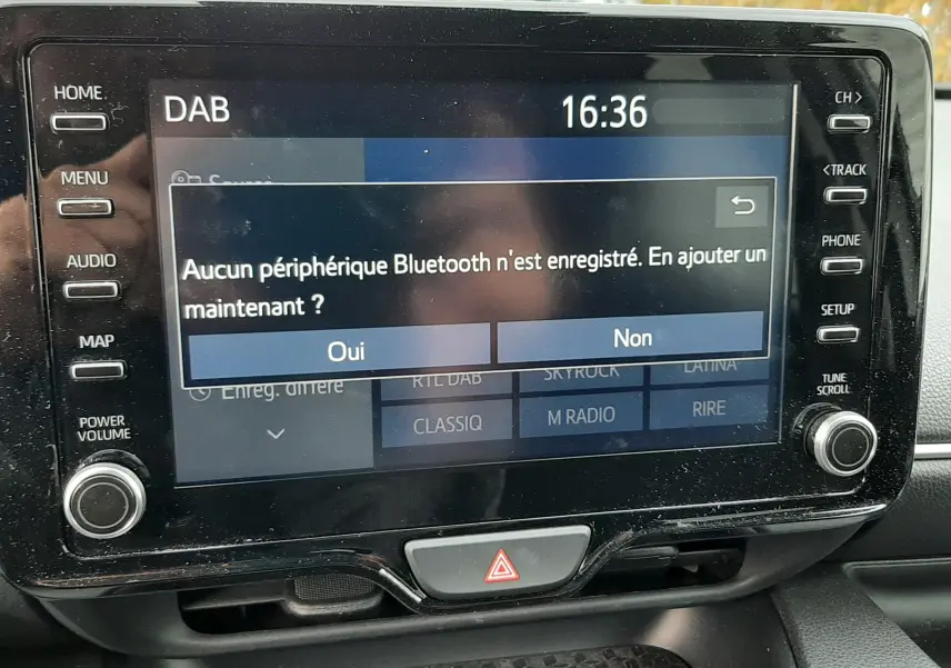 Écran tactile central de la Toyota Yaris 2023 affichant un message Bluetooth, avec boutons de contrôle autour.