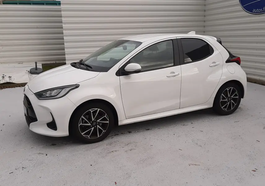Toyota Yaris blanche vue de profil côté gauche, avec jantes alliage bicolores et toit compact cinq portes.