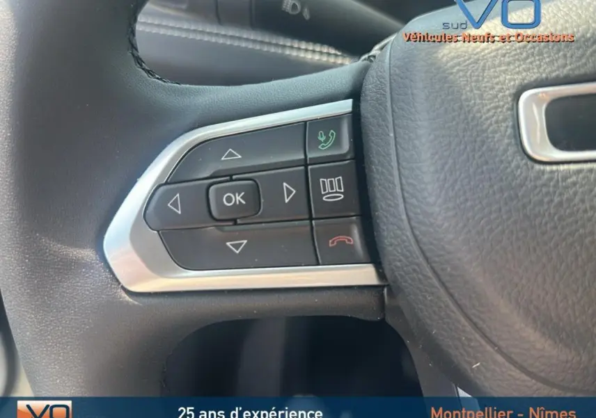 Gros plan sur les commandes au volant du Jeep Compass blanc 2024, version e-Hybrid Altitude.