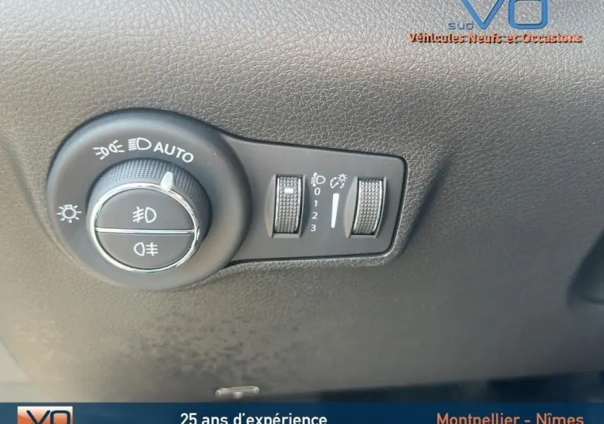 Gros plan sur le bouton de commande des phares du Jeep Compass blanc 2024, avec réglages d'éclairage et pack hiver visible.