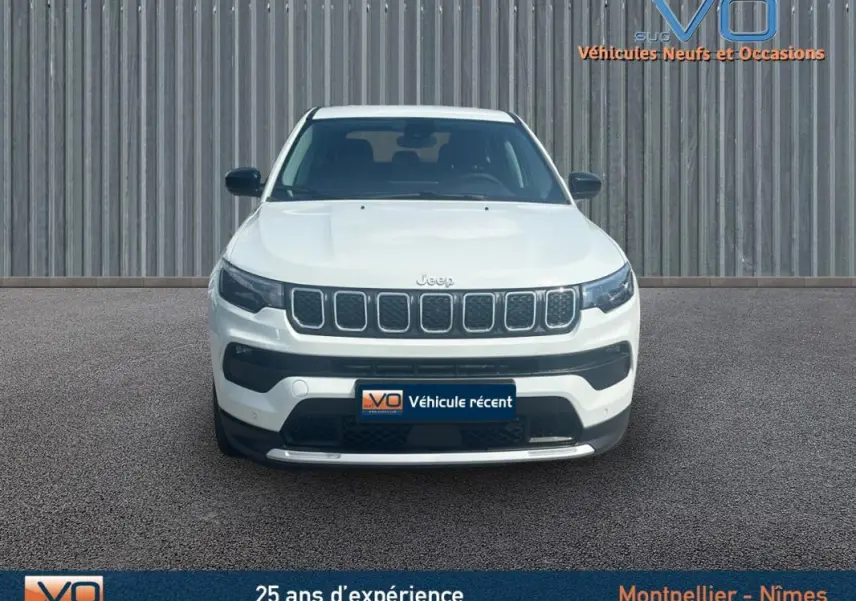 Vue frontale d'un Jeep Compass blanc 2024 avec calandre distinctive et plaques d'immatriculation du concessionnaire.