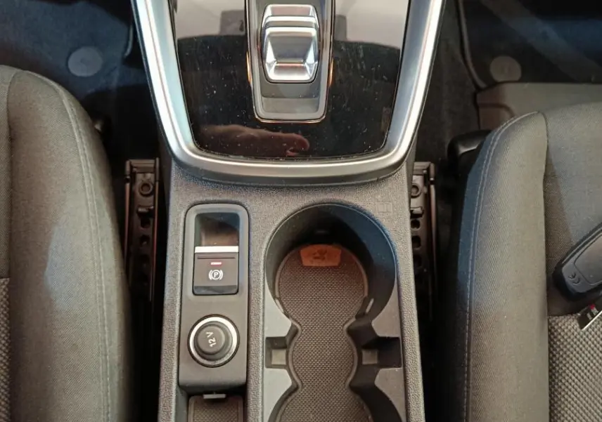 Vue plongeante sur la console centrale noire de l'Audi A3 30 TFSI MHEV avec levier de vitesse automatique et porte-gobelets.