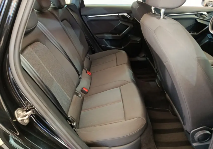 Vue intérieure côté gauche de la banquette arrière noire de l'Audi A3 30 TFSI MHEV Business Line 2022.