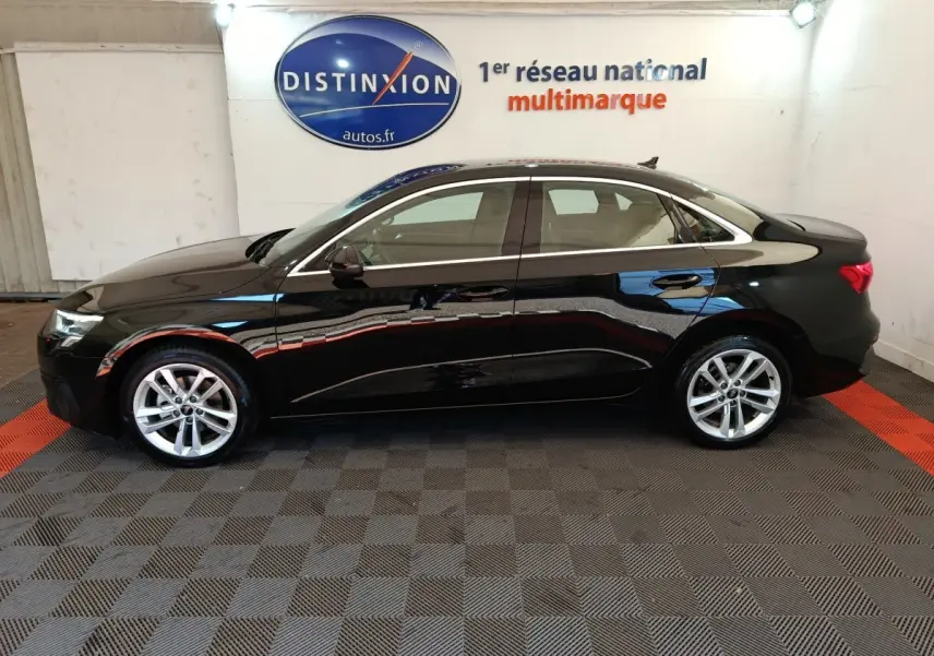 Audi A3 noire vue de profil côté gauche dans un showroom avec logo Distinxion en arrière-plan.