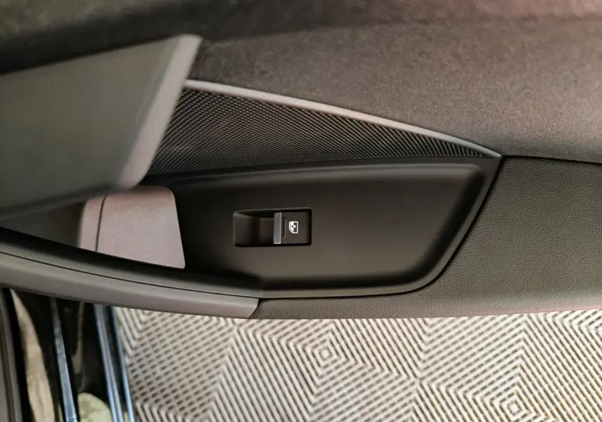 Gros plan sur le bouton de commande de lève-vitre côté gauche de la porte d'une Audi A3 noire 2022.
