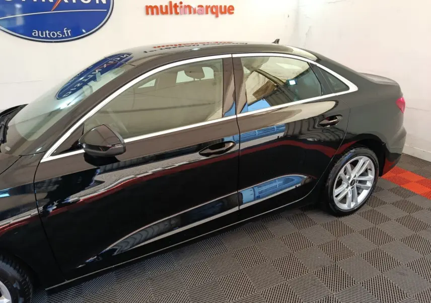 Profil côté gauche d'une Audi A3 Business Line noire 2022, avec jantes alliage et rétroviseurs noirs brillants.