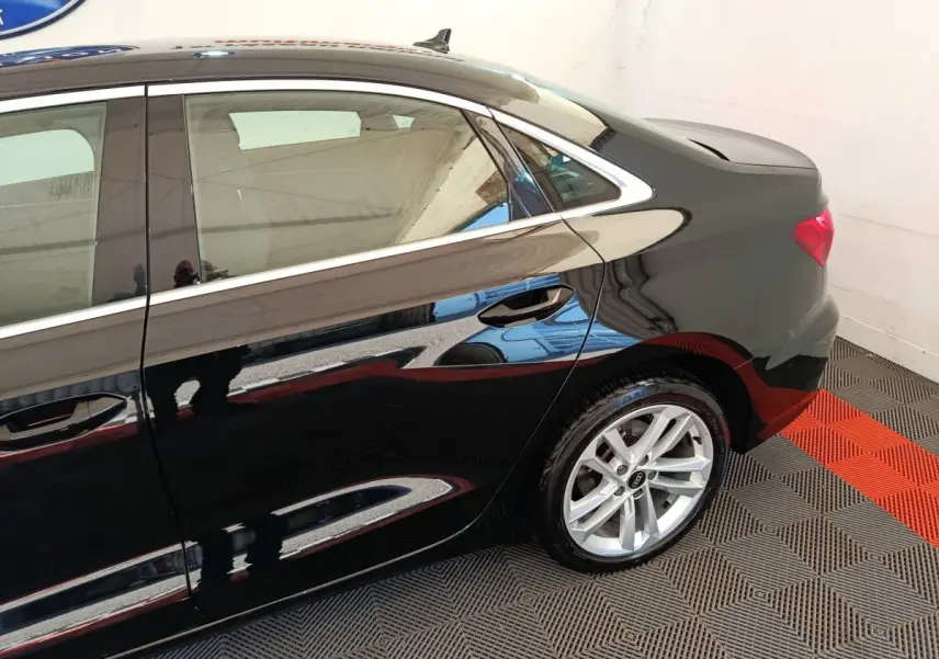 Profil arrière droit d'une Audi A3 noire 2022 avec jante argentée et poignées de porte intégrées.