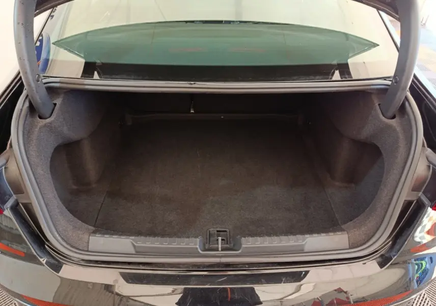 Coffre ouvert vu de l'arrière d'une Audi A3 noire 2022, montrant un espace de chargement vide et propre.