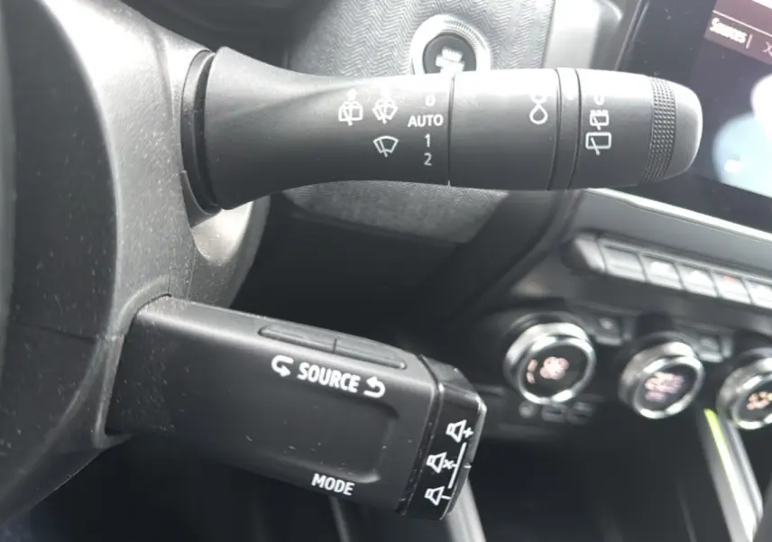 Détail du commodo multifonctions et commandes de climatisation dans l’habitacle de la Renault Clio V TCe 90 Techno Plus.